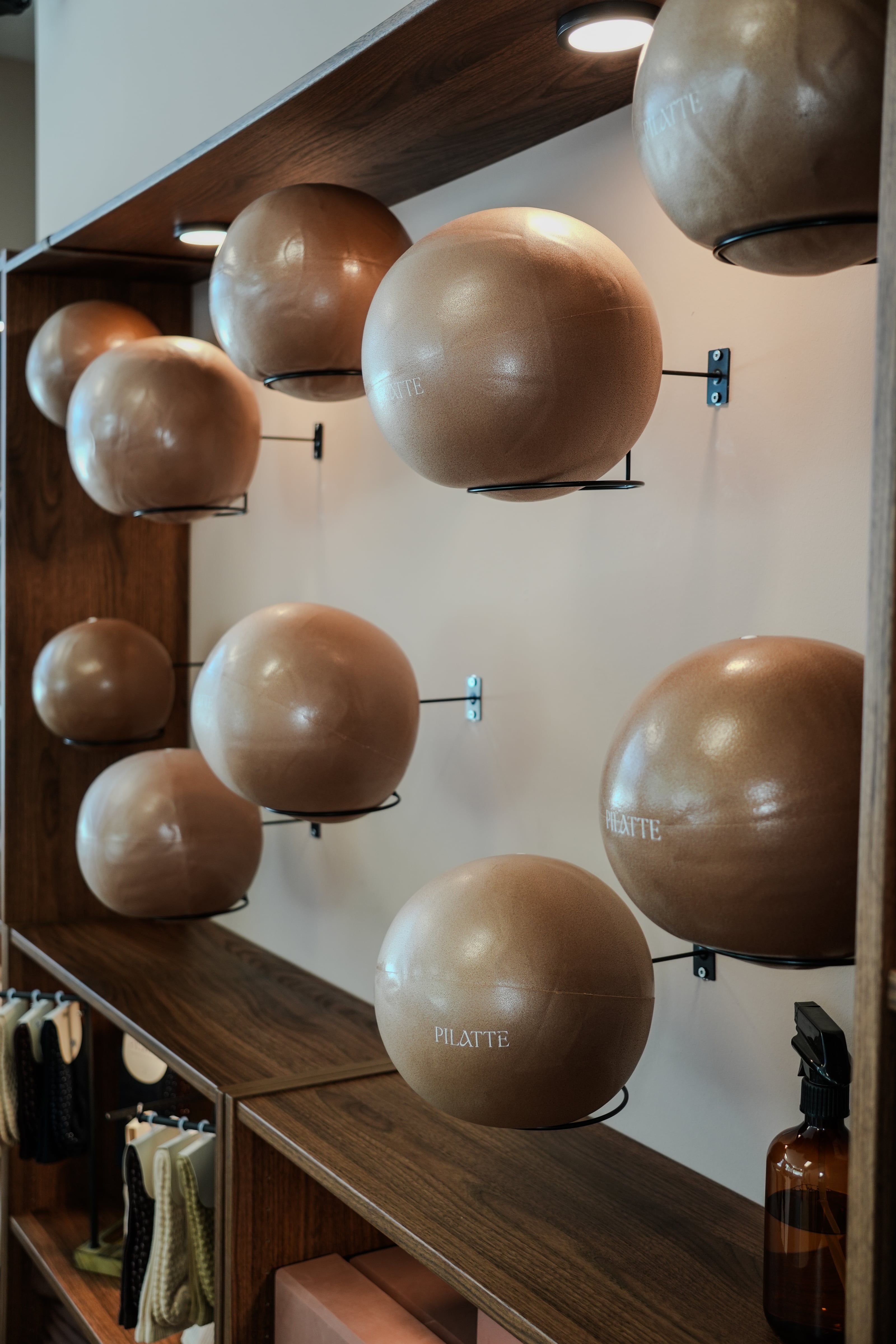 Gewichtsbälle mit Pilatte-Aufdruck an der Wand zwischen den Regalen