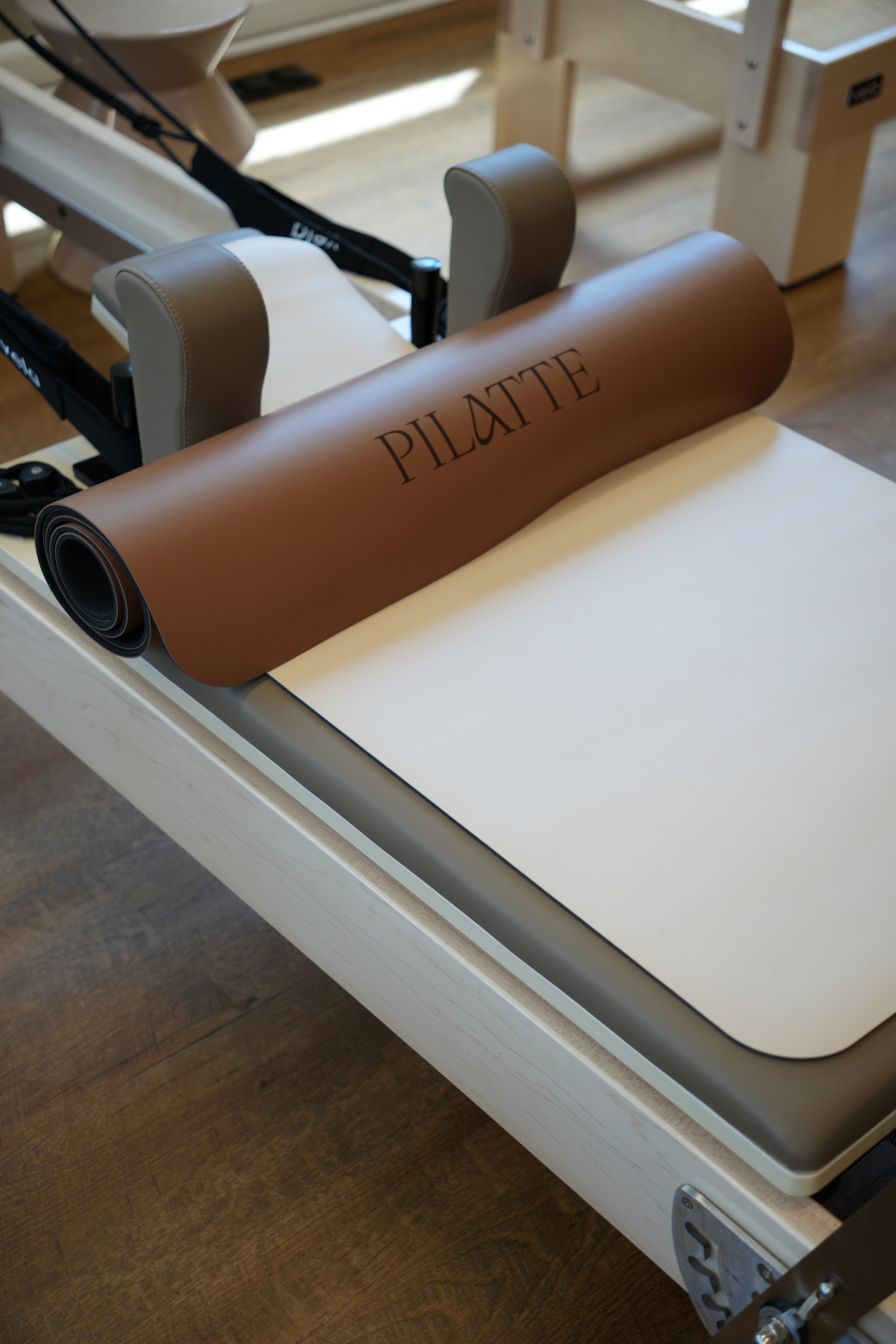 Gerollte Matte mit Pilatte-Aufdruck auf dem Schlitten eines Reformers