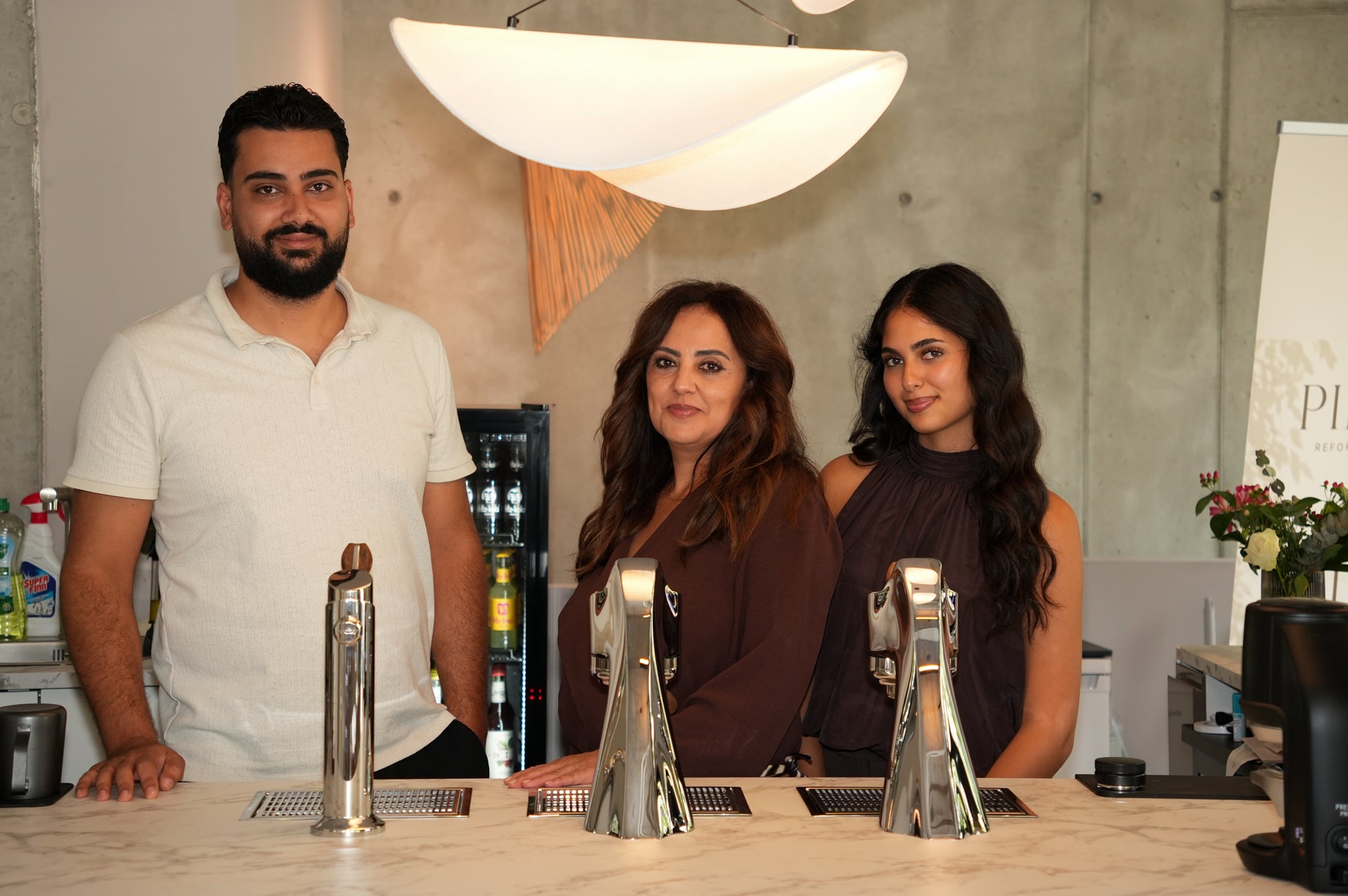 Cem, Serap und Sara hinter dem Tresen des Cafés